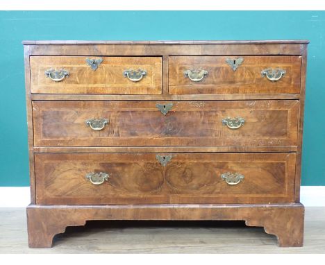 A Georgian walnut Chest with moulded top above two short and three long cross banded and feather banded drawers with brass sw