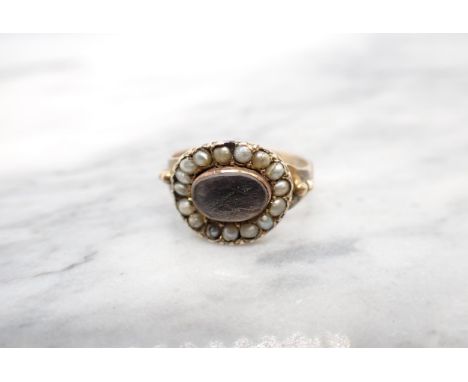 A Georgian Mourning Ring having enclosed lock of hair within seed pearl frame, inscription dated 1800 verso, ring size N 