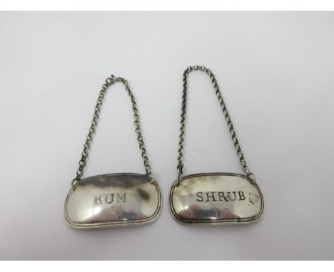 A pair of George III silver oval Labels, Rum and Shrub, Sheffield 1817, maker: Kirkby, Waterhouse &amp; Co 