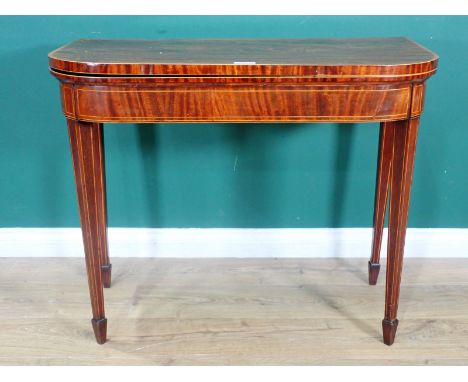 A 19th Century mahogany fold-over Card Table with satinwood stringing, raised on squared tapering supports and casters