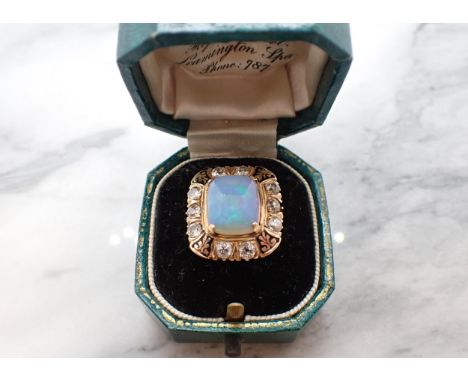 An Opal, Diamond and Enamel Ring corner claw-set rectangular opal cabochon within a frame of ten old-cut diamonds and black e