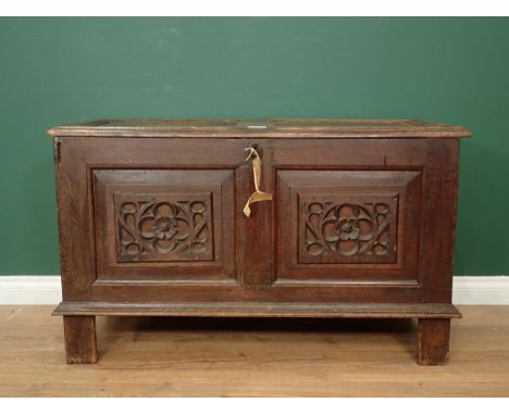 A 17th Century oak Coffer with sunken two panel lid above two earlier tracery carved rosette front panels and end panels moun