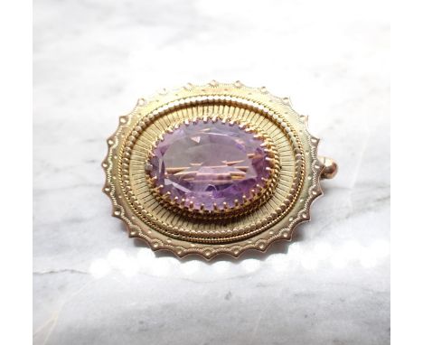 An Amethyst Brooch claw-set oval-cut stone within beaded and scalloped frame in 9ct gold, approx 28mm wide, approx 4.90gms 