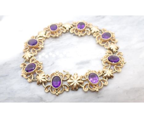 An Amethyst Bracelet comprised of eight openwork scrolled links each set oval-cut stone in 9ct gold, approx 31gms all in 