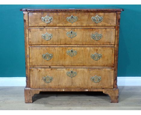 An early Georgian walnut Chest, the moulded top cross-banded in rosewood, with fluted chamfered corners to the front and fitt
