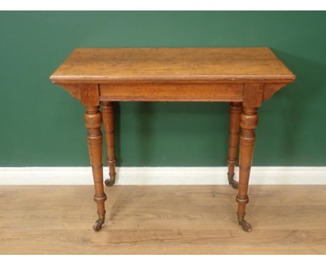 A Constantine &amp; Co oak Card Table with folding and revolving top, raised on turned tapering supports and casters 