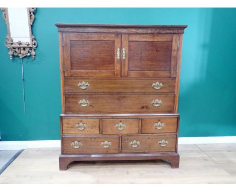 A Georgian and later oak Cupboard on stand, having moulded cornice above pair of solid panel doors enclosing shelves, with du