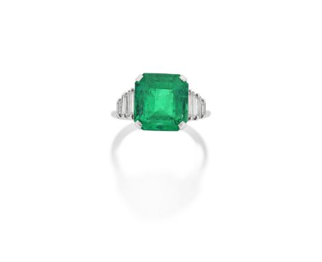 EMERALD AND DIAMOND RINGThe step-cut emerald, weighing 7.28 carats, between stepped baguette-cut diamond shoulders, ring size