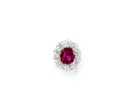 RUBY AND DIAMOND CLUSTER RINGThe oval-cut ruby, weighing 8.22 carats, within a surround of brilliant-cut diamonds, issuing fr