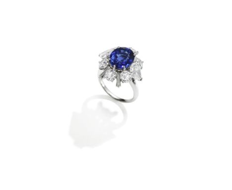 SAPPHIRE AND DIAMOND RINGThe oval-cut sapphire, weighing 6.31 carats, within a surround of pear-shaped, brilliant and tapered