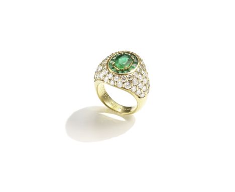 BOUCHERON: EMERALD AND DIAMOND RING, CIRCA 1985The oval-cut emerald within a surround of calibré-cut emeralds, in a brilliant