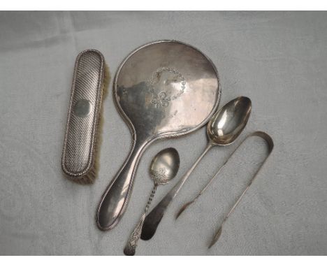 A small selection of HM silver including a hand mirror with ribbon swag decoration, clothes brush with engine turned decorati