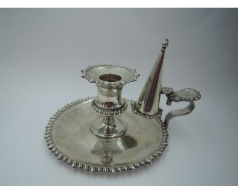 An Edwardian silver chamber stick and snuffer having gadrooned decoration to base rim, sconce and snuffer with monogrammed ha