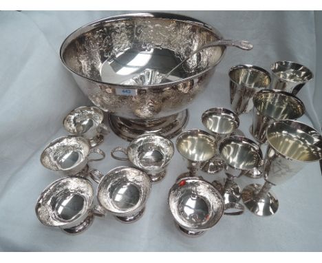 A large silver plated punch bowl having scroll decoration and plain cartouche, with six punch cups (all cups damaged), a punc