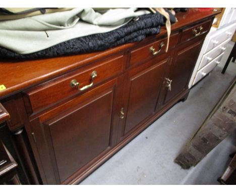 A modern mahogany sideboard having three inline drawers and three panelled doors, raised on bracket feet, 36 h, 65 w