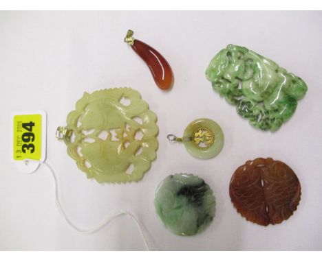 A jade circular pendant and companion, both with yellow metal mounts, and four further pendants, two decorated with carp