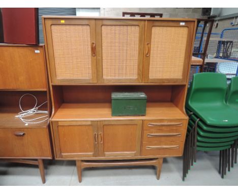 A vintage teak G plan sideboard of compact design having woven panel cupboards over