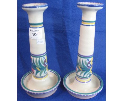 Pair of Carter, Stabler and Adams Poole Pottery candlesticks with typical florally painted banded decoration, having terracot