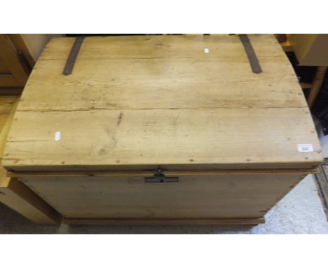 A pine dome top trunk with wrought iron mounts on turned bun feet