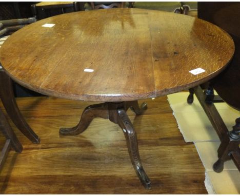 An early 19th Century oak tea table, the circular snap top on a turned pedestal on tripod base (cut down)