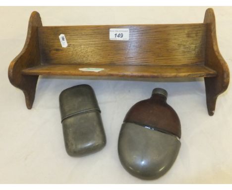 An oak book trough with embossed white metal decoration, a leather and pewter covered glass hip flask, and a pewter Sykes hip