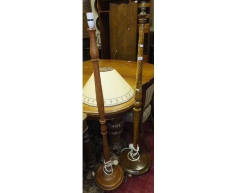 An oak standard lamp on circular base and another further standard lamp 