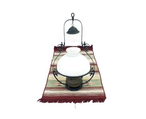 Wrought iron framed hanging oil lamp, with a brass reservoir and opaque glass circular shade, 33" high approx; together with 