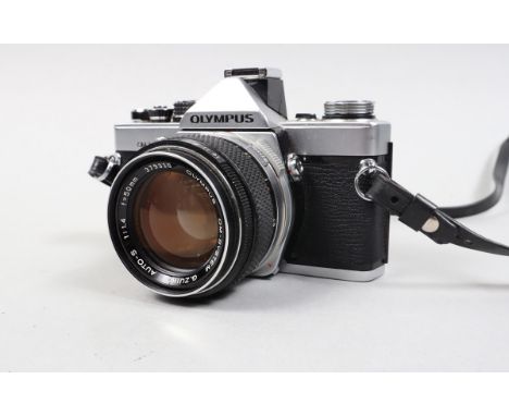 An Olympus OM 2 SLR Camera, serial no 573998, shutter working, meter responsive, body G-VG, with G Zuiko 50mm f/1.4 Auto-S le