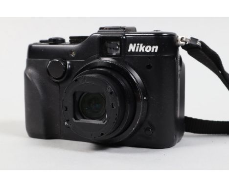 A Nikon Coolpix P7100 Digital Camera, powers up, appears to function as should,body G, missing name bezel from lens front, wi