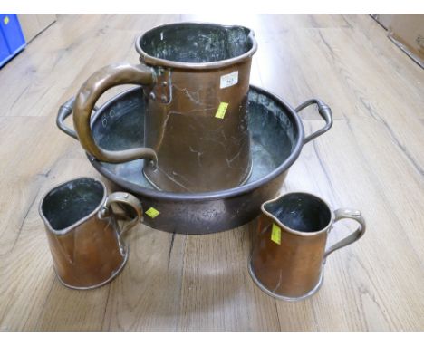 Copper two handled basin, 40 cm diameter, and three copper jugs, tallest 26 cm