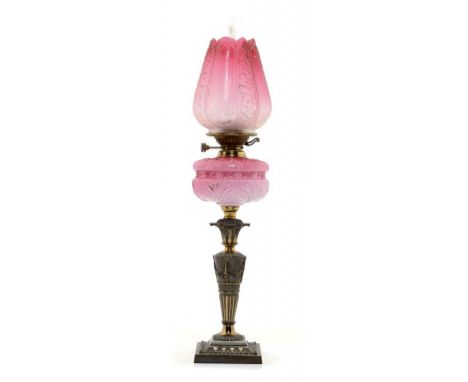 A VICTORIAN PATINATED BRASS OIL LAMP, C1890  with moulded pink glass fount and Young's brass burner, moulded and etched cranb