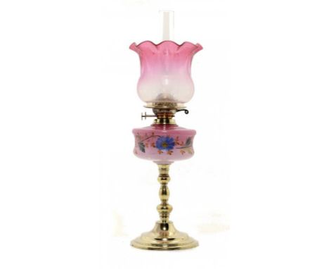A VICTORIAN BRASS OIL LAMP, C1890 the pink shaded glass fount enamelled with flowers, brass Duplex burner, etched cranberry g