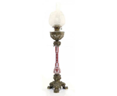 A VICTORIAN GILT BRASS MOUNTED OVERLAY GLASS OIL LAMP, C1870 the baluster shaft of cranberry glass overlaid in white and cut 
