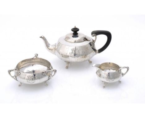 AN ART NOUVEAU SILVER THREE PIECE HAMMER TEXTURED TEA SERVICE  with whiplash handles, teapot 11.5cm h, by Charles Edwards, Lo