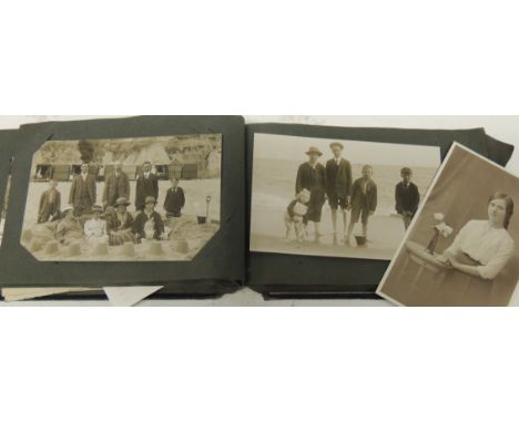 An album of early 20th Century photographic portrait postcards - family groups, children, small boy on toy horse, military, g