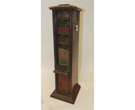 An Edwardian penny operated Automatic cigarette dispenser; the wood case with instructions painted to the front glass panel, 