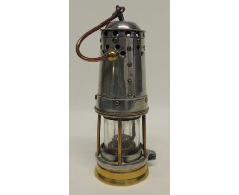 A miners lamp having brass base, white metal top with curved copper and brass suspension hook, with original burner, no makes