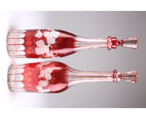 A PAIR OF BOHEMIAN RUBY FLASHED GLASS DECANTERS AND STOPPERS, each decorated with fruiting vine. 34.5cm high