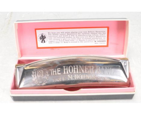 A vintage 'The Hohner Band ' harmonica musical instrument, constructed from white metal with engraved makers marks,&nbsp; bei