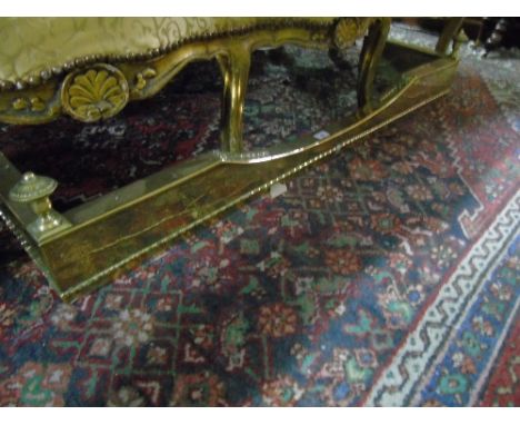 An Early 20th Century Pressed Brass Fender With Turned Finial Corners.