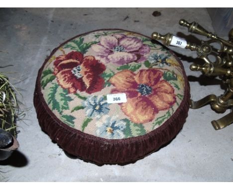 A 19th Century Foot Stool, having a floral tapestry top standing on three shallow bun feet.