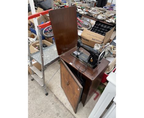 A VINTAGE SINGER SEWING MACHINE WITH WOODEN TREADLE BASE CABINET 