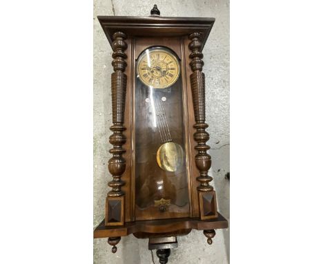 A CARVED WALNUT VIENNA WALL CLOCK WITH ROMAN NUMERALS AND PENDULUM 