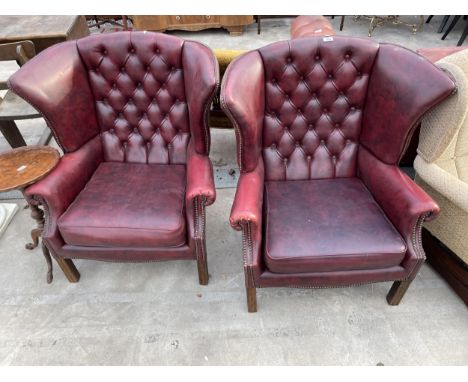 A PAIR OF MODERN BUTTON-BACK WINGED OXBLOOD FIRESIDE CHAIRS 