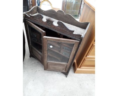 A LATE VICTORIAN OAK GLAZED TWO DOOR SMOKERS CABINET ENCLOSING SEVEN DRAWERS AND TWO PIPE RACKS, 21.5" WIDE 