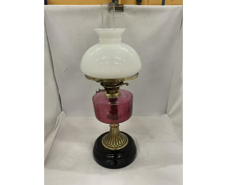 A VINTAGE OIL LAMP WITH WHITE GLASS SHADE, GLASS FUNNEL, CRANBERRY COLOURED GLASS OIL RESERVOIR 