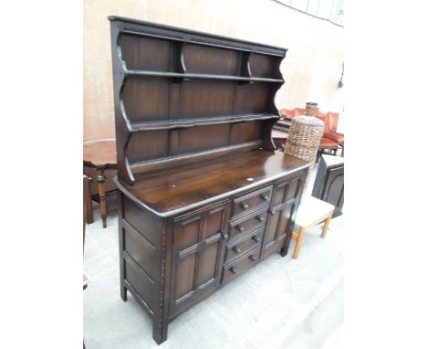 AN ERCOL COLONIAL DRESSER ENCLOSING FOUR DRAWERS AND TWO CUPBOARDS TO THE BASE, COMPLETE WITH PLATE RACK, 58" WIDE 