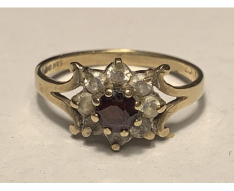 A 9 CARAT GOLD RING WITH CENTRE GARNET SURROUNDED BY CUBIC ZIRCONIAS SIZE L 