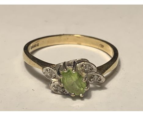 A 9 CARAT GOLD RING WITH A CENTRE PERIDOT SURROUNDED BY DIAMONDS IN A LEAF DESIGN SIZE O/P 