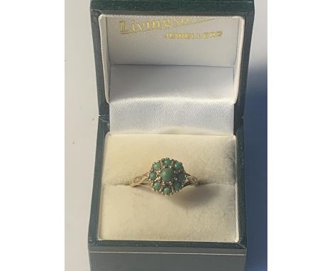 A 9 CARAT GOLD RING WITH GREEN STONES IN A FLOWER DESIGN SIZE R GROSS WEIGHT 3.34 GRAMS IN A PRESENTATION BOX 